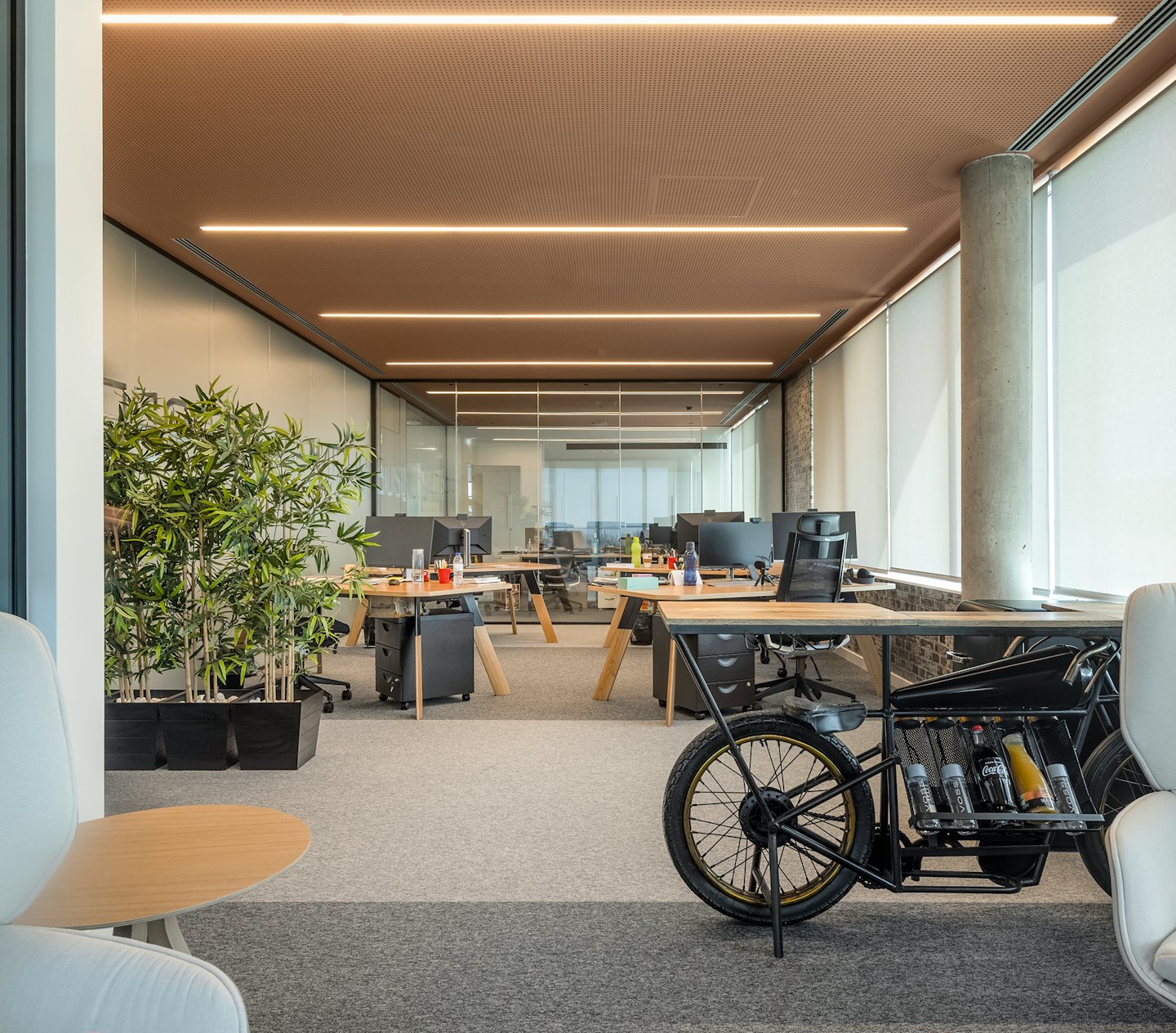 Modernes Büro mit einzigartigem Motorradschreibtisch und Pflanzen.