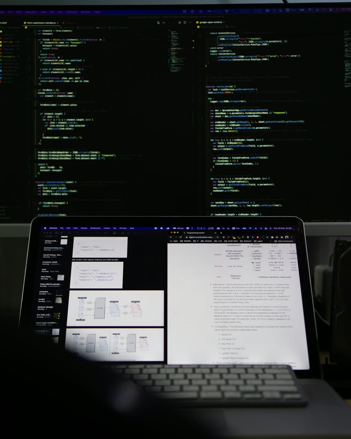 Zwei Computermonitore zeigen Codezeilen auf einem Schreibtisch.